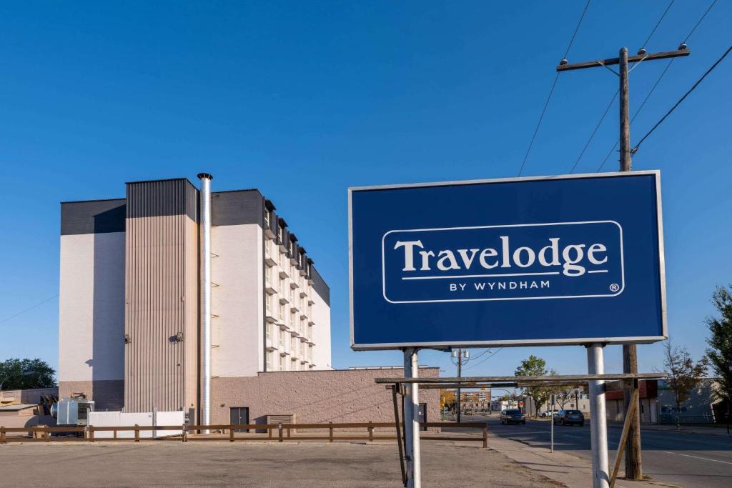 a sign in front of a large building at Travelodge by Wyndham Prince Albert in Prince Albert