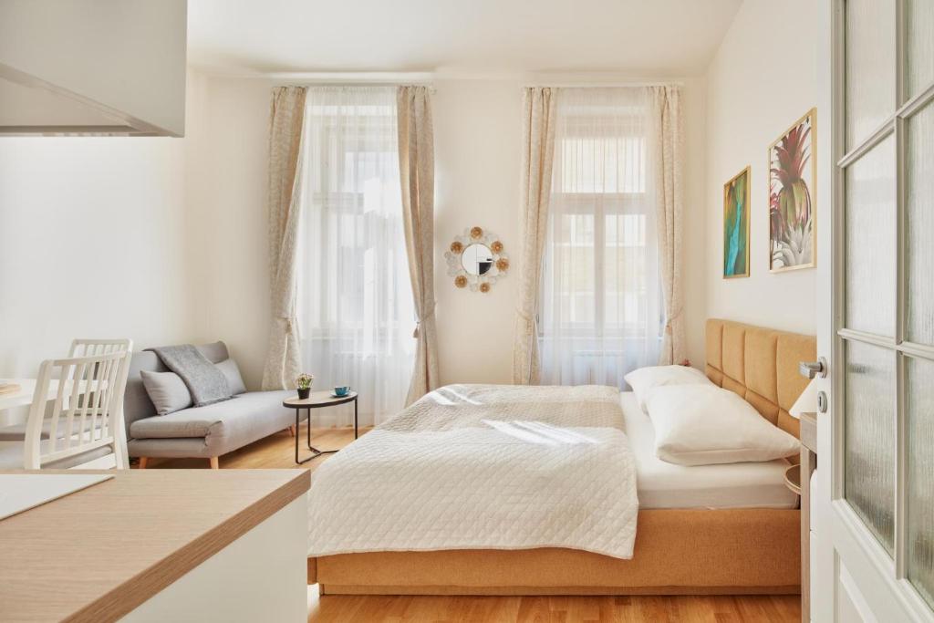 een kleine slaapkamer met een bed en een stoel bij Elegant Studio in New Town by Prague Days in Praag