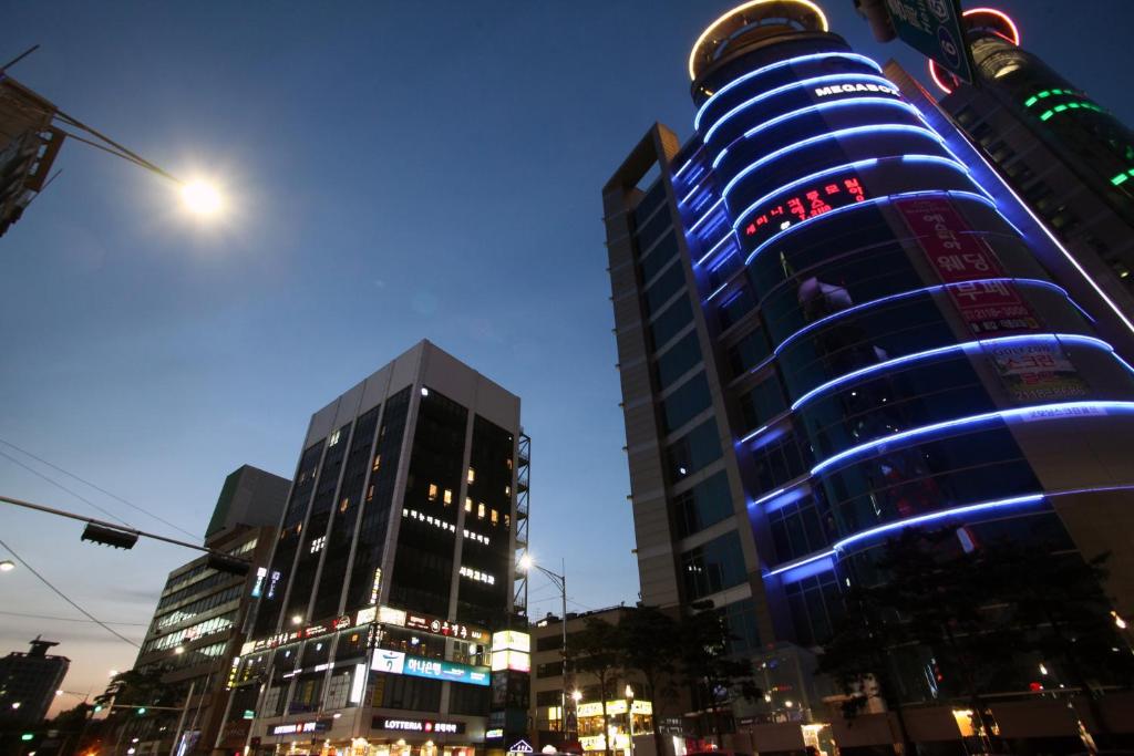 a tall building with blue lights on it in a city at KSTAR METRO Hotel in Seoul