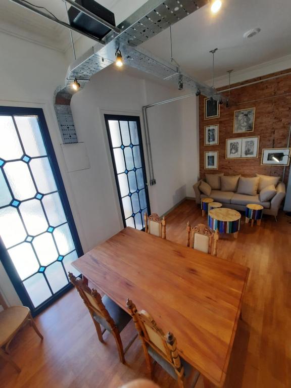 Habitación grande con mesa de madera y sofá. en Mendoza in en Mendoza