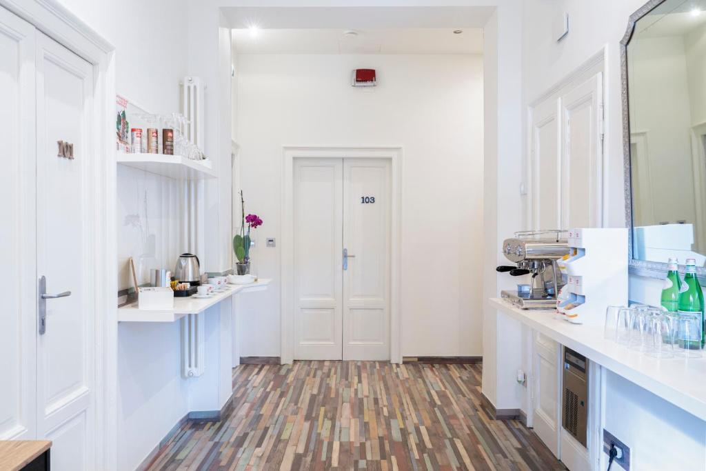 uma cozinha com paredes brancas e piso em madeira em Varese Suites em Varese