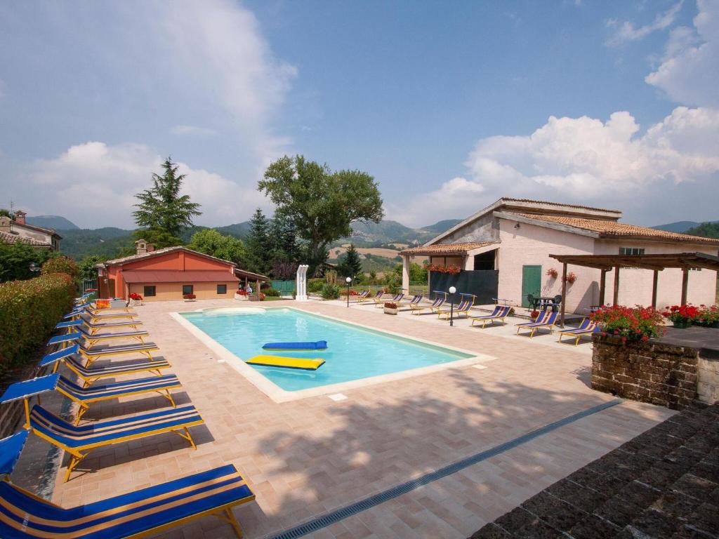 a swimming pool with lounge chairs and a house at Lush holiday home in Urbania with bubble bath in Urbania