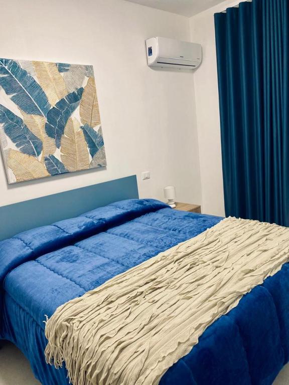 sypialnia z łóżkiem z niebieską kołdrą w obiekcie Chalaroste home w mieście Terrasini