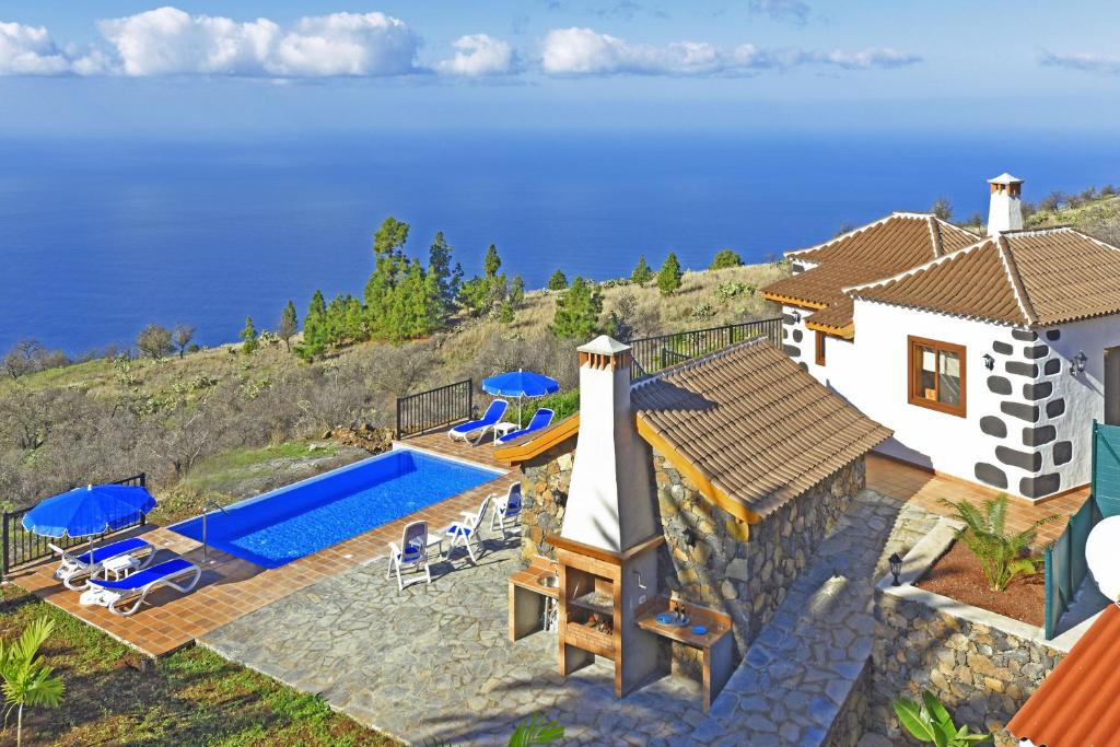 a house with a swimming pool next to the ocean at Casa Rural Pastor in Tijarafe