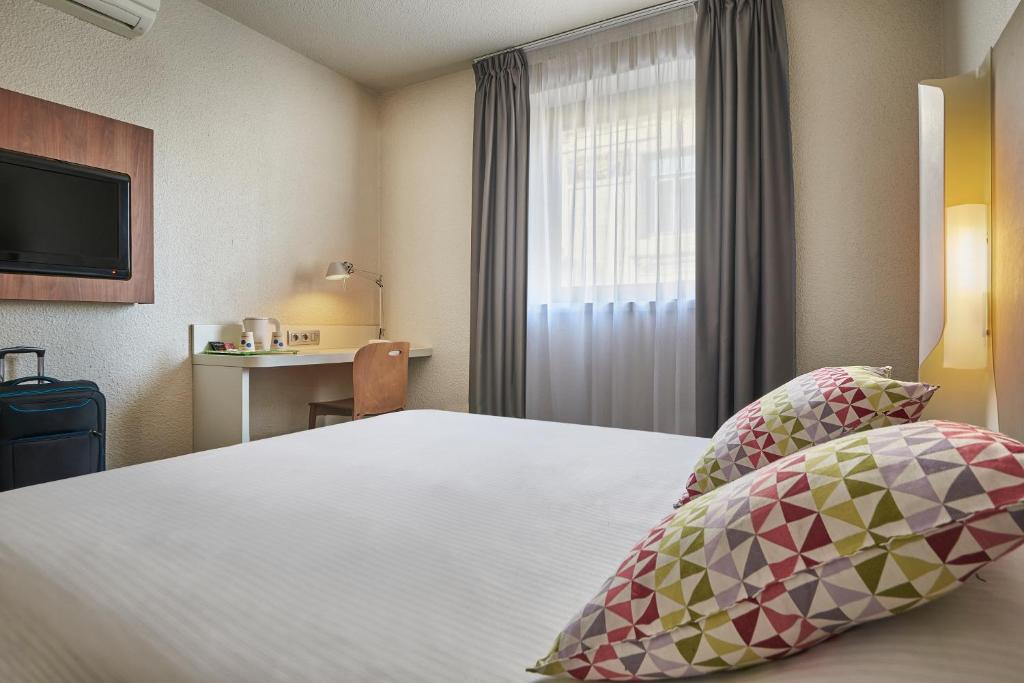 a hotel room with a bed and a window at Campanile Lyon Centre - Berges du Rhône in Lyon