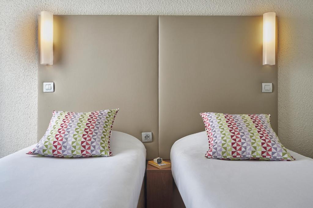 two beds sitting next to each other in a room at Campanile Lyon Centre - Berges du Rhône in Lyon