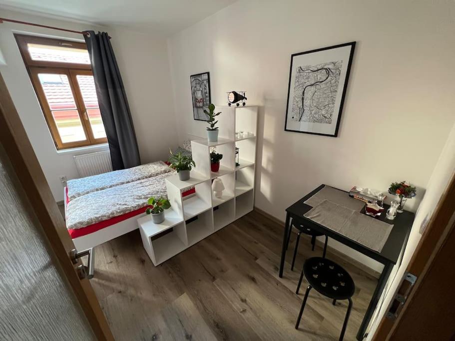 ein kleines Schlafzimmer mit einem Schreibtisch, einem Bett und einem Tisch in der Unterkunft Modern apartment Krymská & Francouzská street in Prag