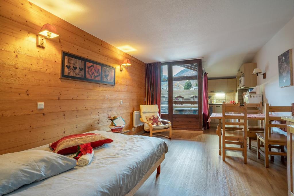 um quarto com uma cama e uma sala de jantar em Grand studio tout confort pour 4 personnes em Brides-les-Bains