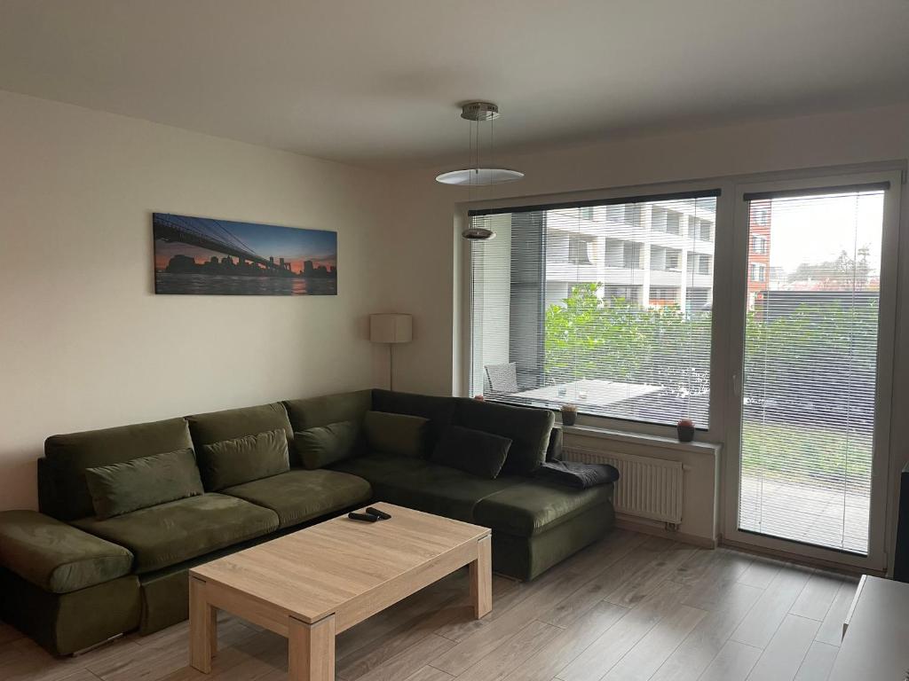 a living room with a green couch and a coffee table at Garden Apartman Radnica in Košice