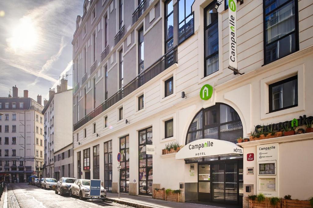 a building on a city street with cars parked outside at Campanile Lyon Centre - Berges du Rhône in Lyon