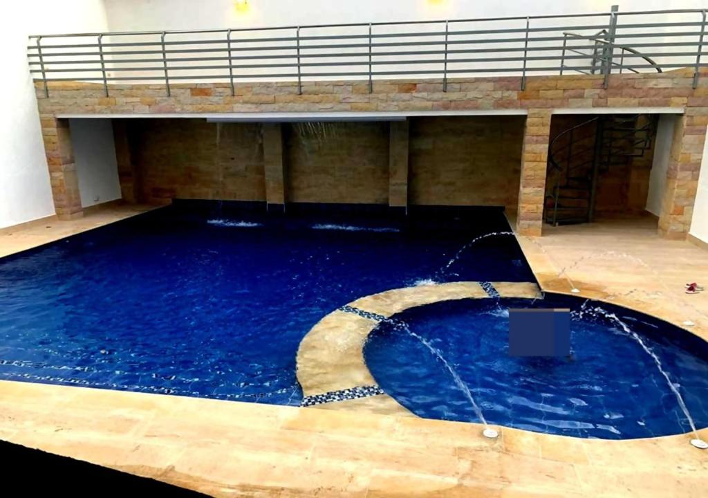 una gran piscina de agua azul en un edificio en KALINA HOTEL, en Girardot