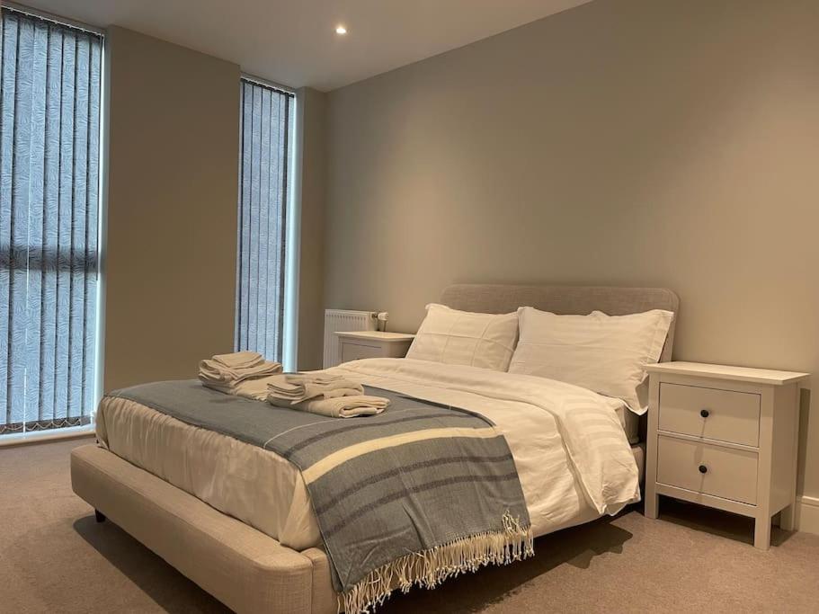 a bedroom with a bed and a large window at Thats The Pad - 2 Bedroom pied-a-terre apartment in Wimbledon in London