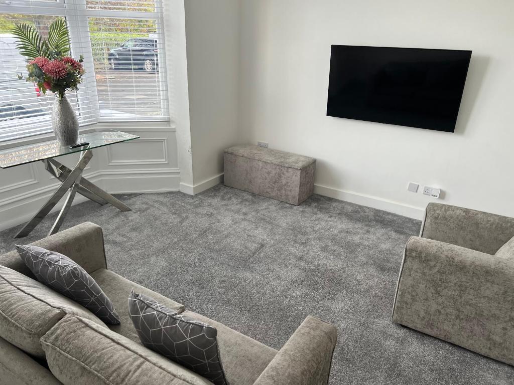 a living room with a couch and a tv at Liley Apartments in Stockton-on-Tees