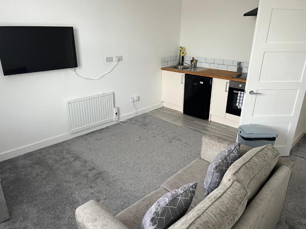 a living room with a couch and a flat screen tv at Liley Apartments in Stockton-on-Tees