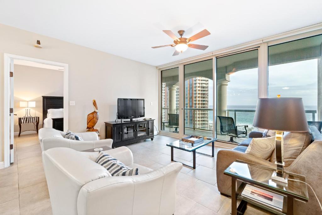 una sala de estar con muebles blancos y vistas al océano. en Portofino Island Resort & Spa Tower Two 1306, en Pensacola Beach