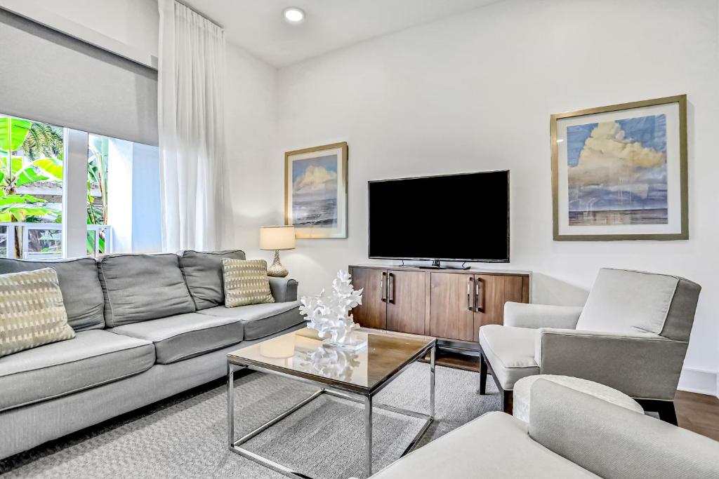 Una sala de estar con un sofá y un televisor. en The Pointe 3-315, en Rosemary Beach