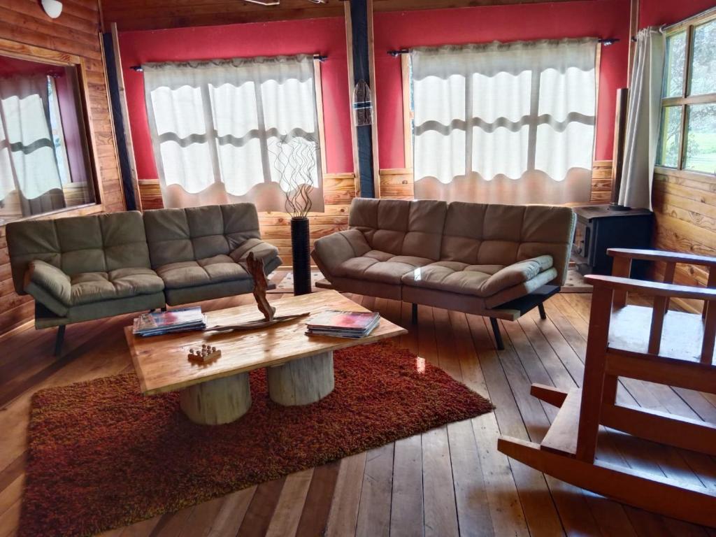 Sala de estar con 2 sofás y mesa de centro en Casa parcela Frutillar en Frutillar