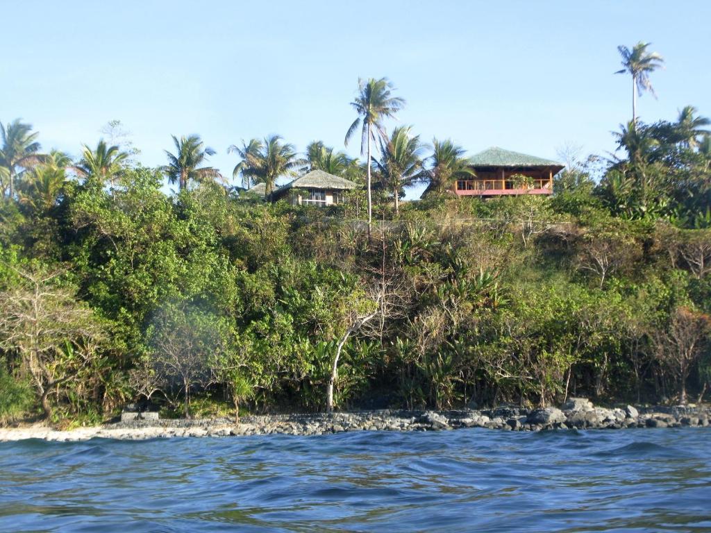 a house on top of a hill next to the water at Blue Seastar Cottages in Agpudlos