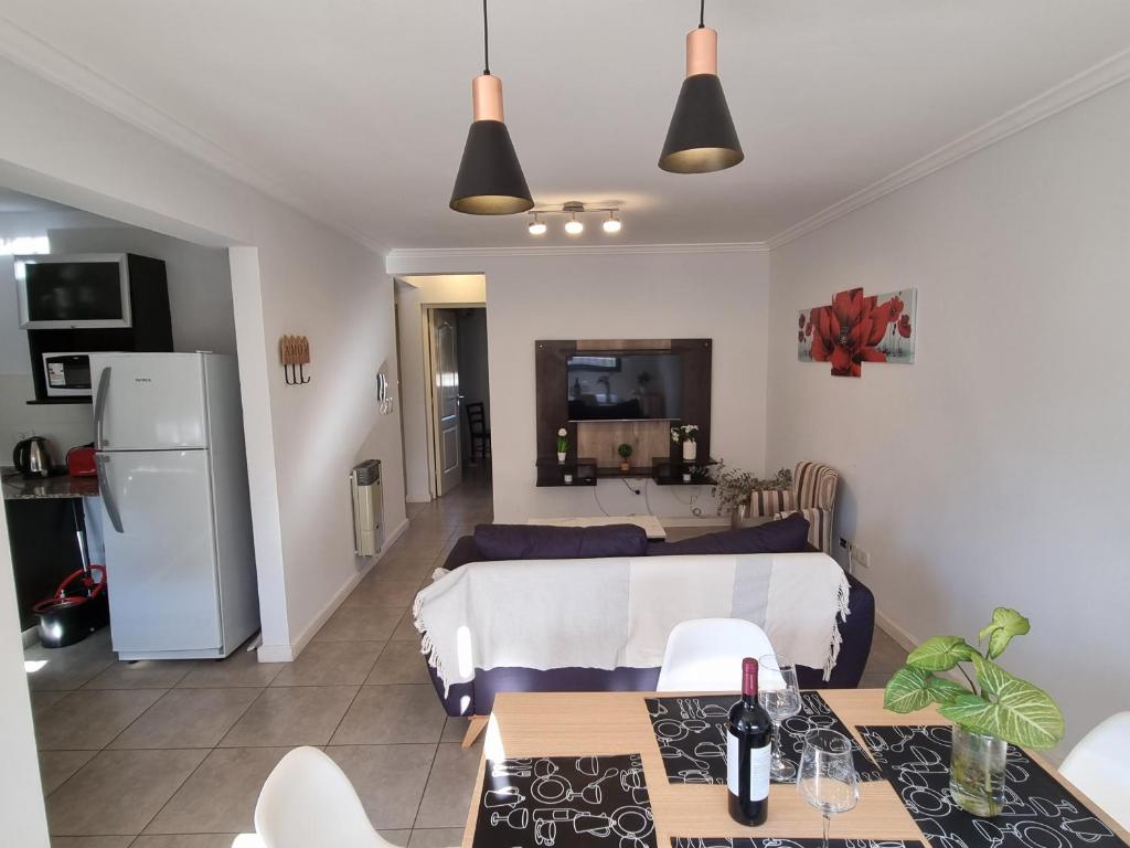 Habitación con cama, mesa y cocina. en Luminoso departamento en zona residencial en Mendoza
