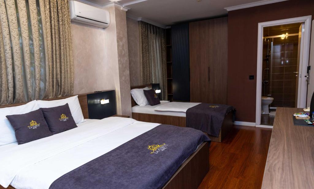 Postel nebo postele na pokoji v ubytování Hotel LaCorte Prishtina