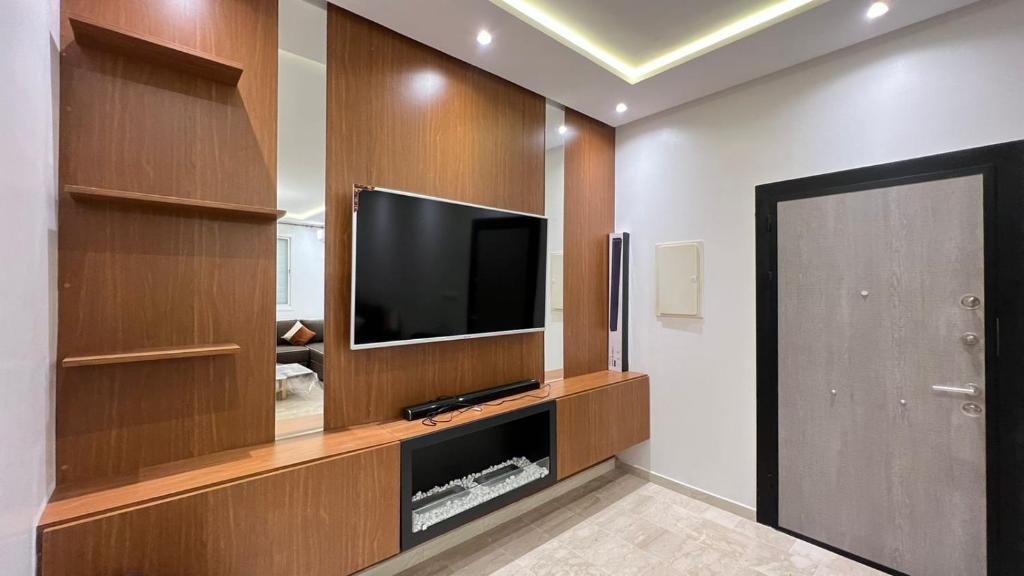 a living room with a flat screen television in a wooden entertainment center at Petit nid douillé au coeur de Casablanca in Casablanca