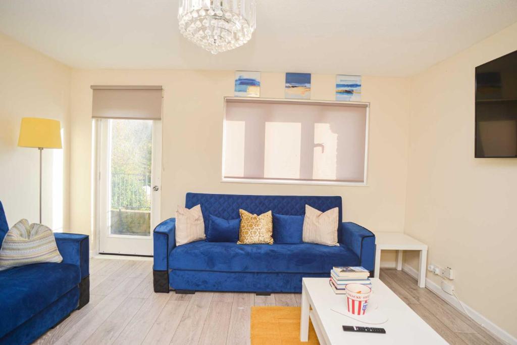 a living room with a blue couch and a table at London's Calling U! A Lovely 2 BedHome Sleeps 1-5! in London