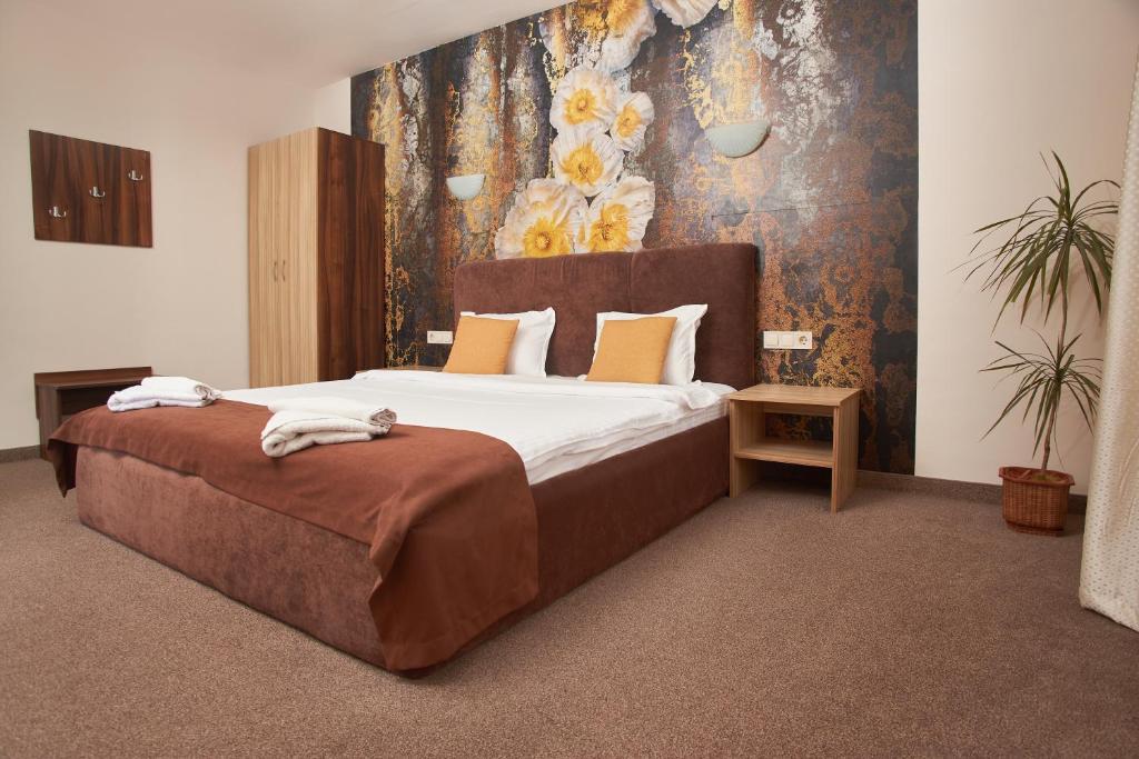 a bedroom with a large bed with a floral wall at Flamingo Plovdiv in Plovdiv