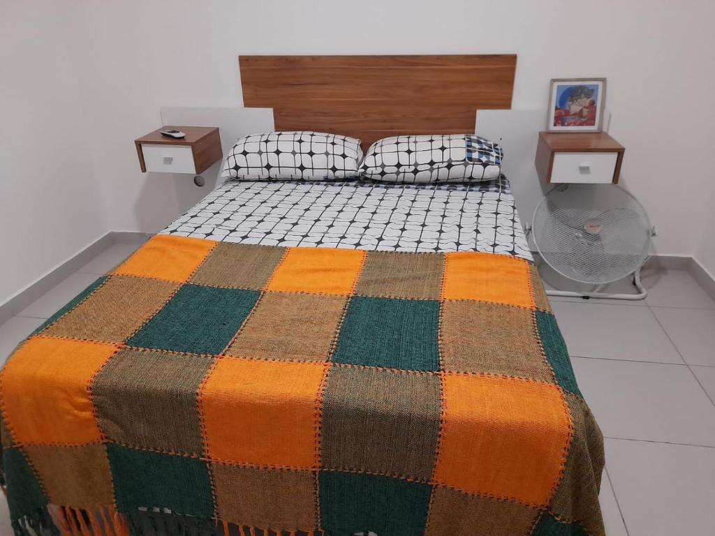 a bedroom with a bed with a colorful blanket at Departamento céntrico in Esperanza