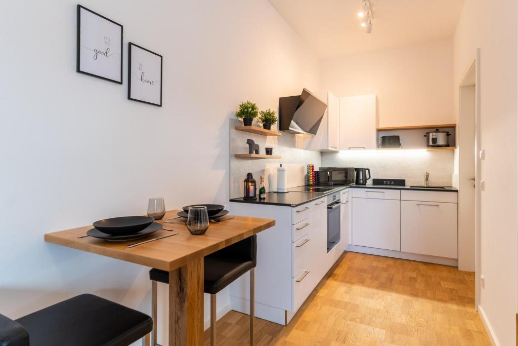 cocina con armarios blancos y mesa de madera en Handmade I Modern I Luxury I Kitchen I Home Office I Netflix, en Holzgerlingen