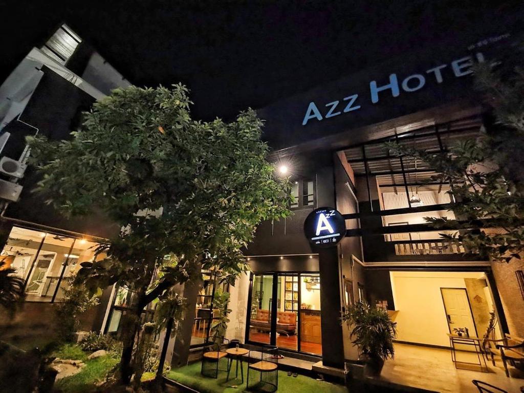 ein Hotel in der Nacht mit einem Baum davor in der Unterkunft Azz Hotel in Chiang Mai