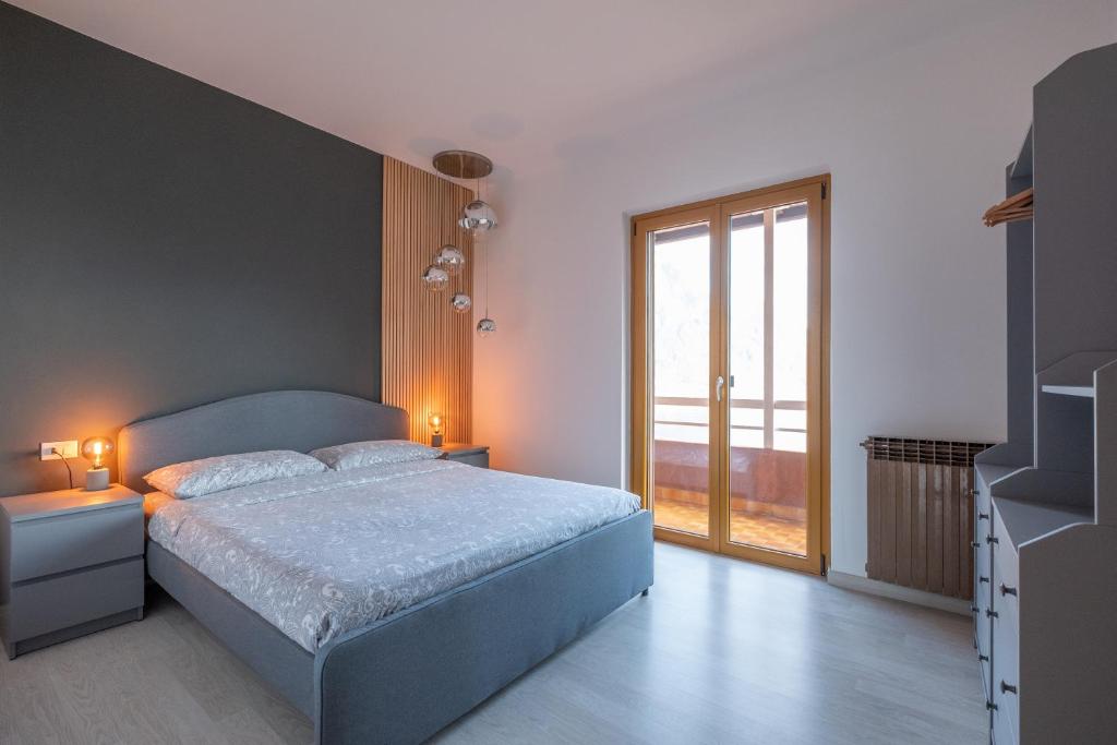 a bedroom with a bed and a large window at Happy Guest Apartments - Dolce Vista in Riva di Solto