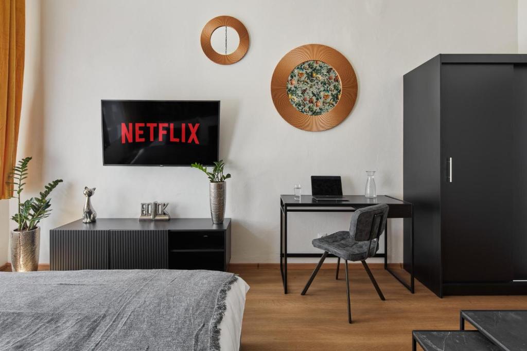 a bedroom with a bed and a desk and a television at Designer Studio in New Town by Prague Days in Prague