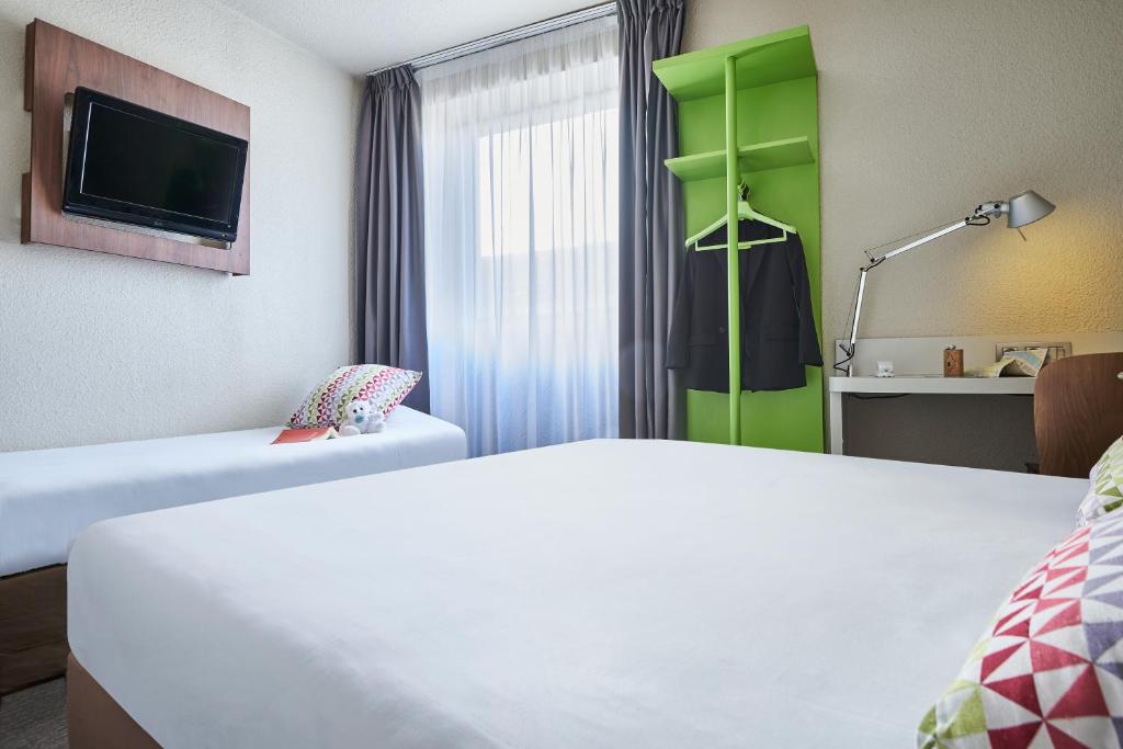 a hotel room with a bed and a tv at Campanile Lyon Centre - Berges du Rhône in Lyon