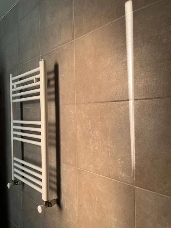 Express Inn في بوتي: جدار من البلاط مع مشعاع في الحمام