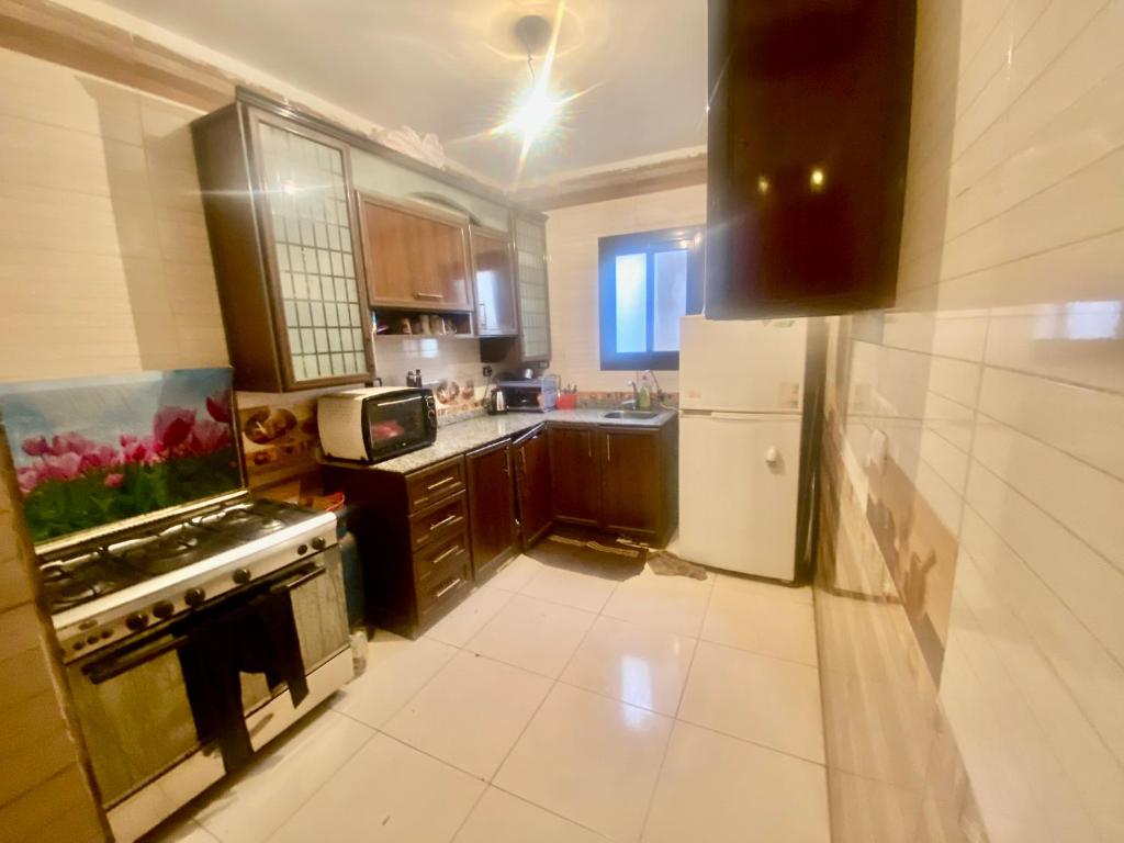Flip apartment في القاهرة: مطبخ مع موقد وثلاجة