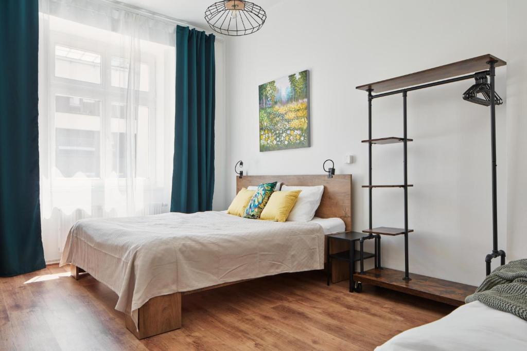 - une chambre avec un lit doté de rideaux bleus dans l'établissement Spacious Apartment in Karlín by Prague Days, à Prague