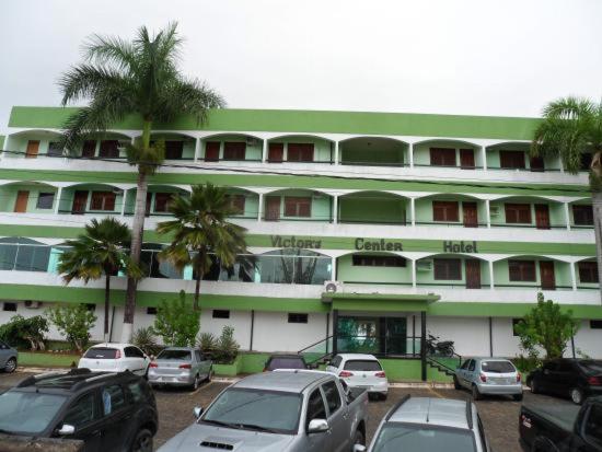 a large building with cars parked in front of it at Victor's Center Hotel in Guarabira