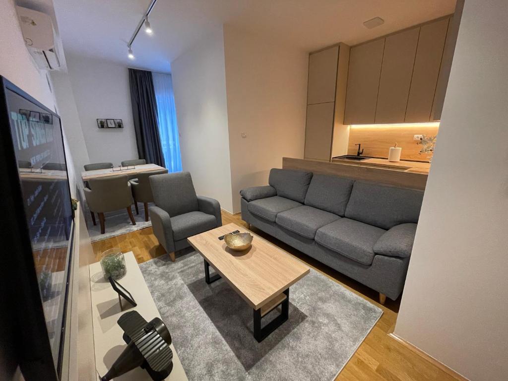 ein Wohnzimmer mit einem Sofa und einem Tisch in der Unterkunft Hills Apartments in Podgorica