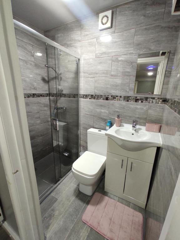 a bathroom with a toilet and a shower and a sink at Private bedroom near NEC, Birmingham airport,city centre in Birmingham