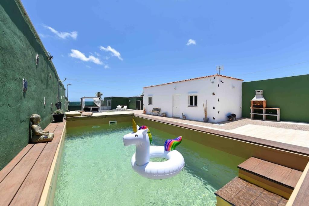 uma piscina com um unicórnio insuflável na água em Villa Candela AirPort em Ingenio