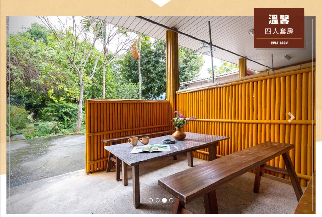 a patio with a wooden table and a bench at Jia Jia Homestay in Yuli