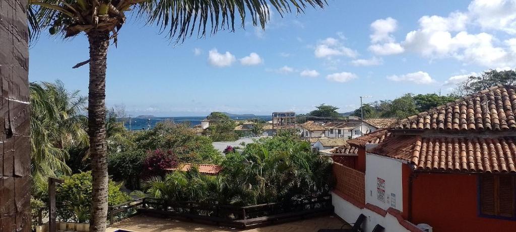 a palm tree standing next to a building with a view at Vista Mar em Búzios Praia de Geribá c/ Piscina in Búzios