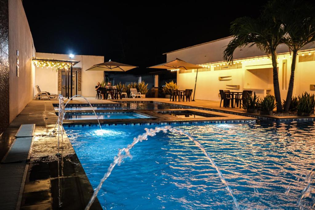 a swimming pool at night with water fountains at Hotel Bella Isa in La Dorada