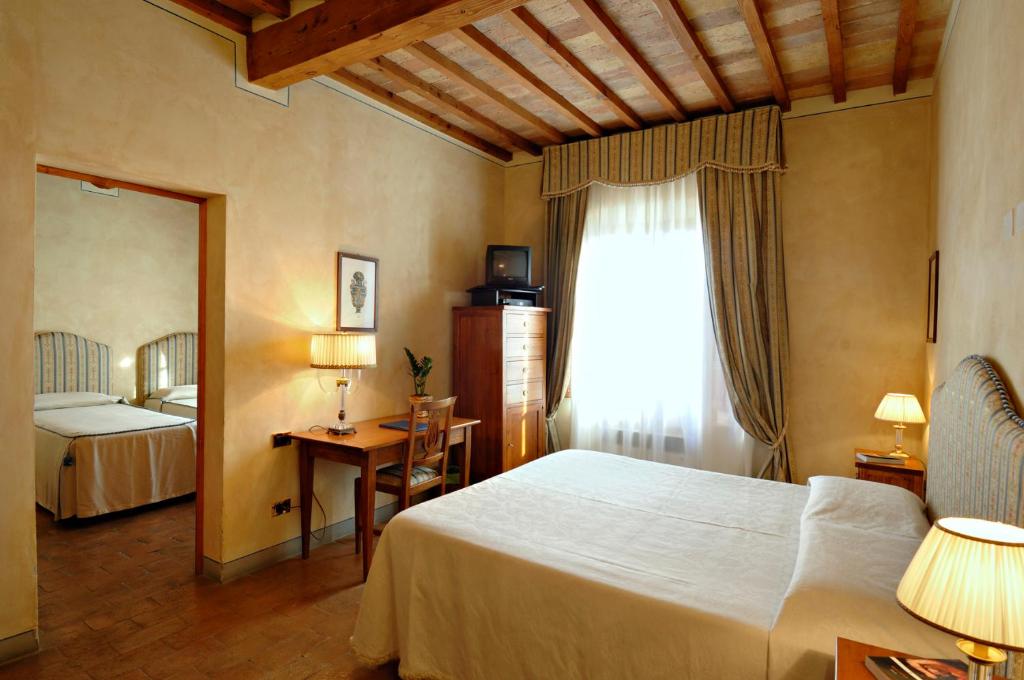 a hotel room with a bed and a window at B&B Palazzo Al Torrione in San Gimignano