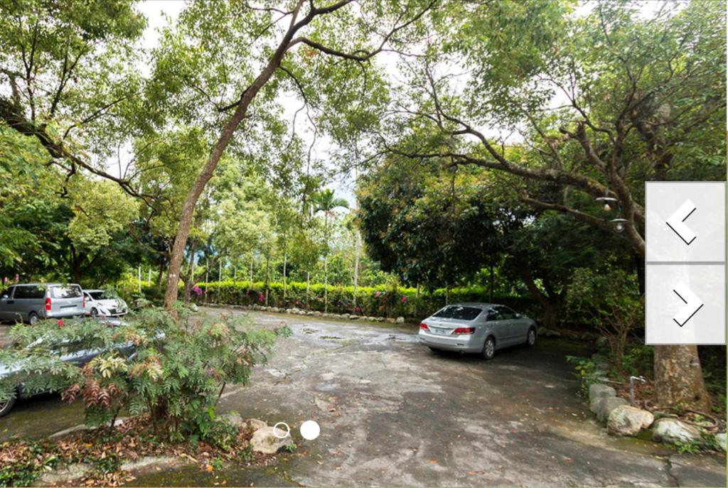 two cars parked in a parking lot with trees at Jia Jia Homestay in Yuli