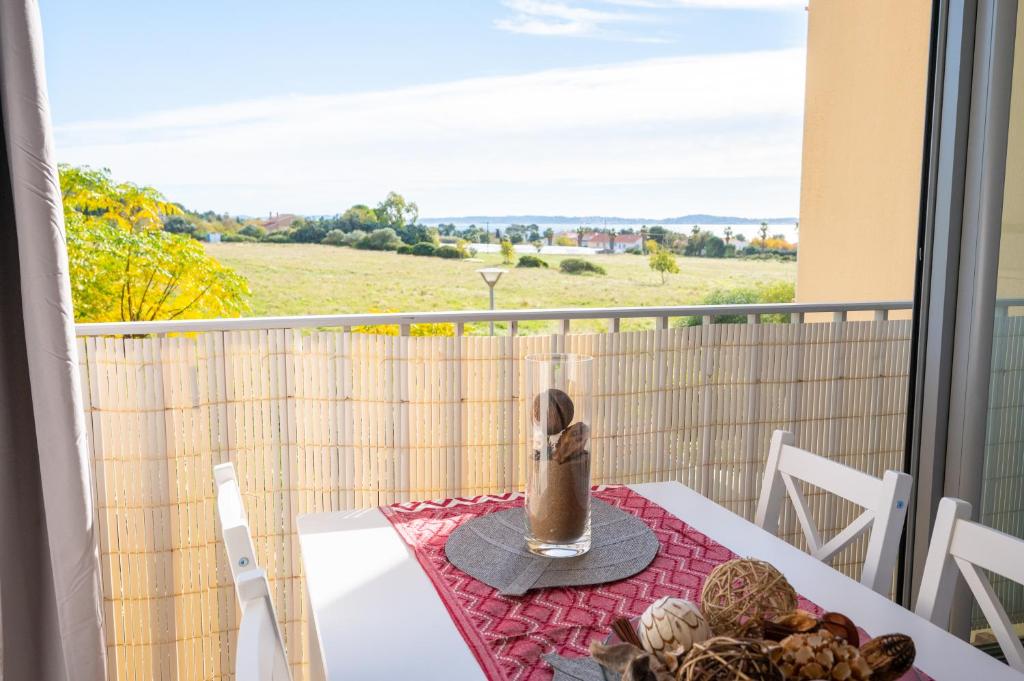 d'une table et de chaises sur un balcon avec vue. dans l'établissement Charmant à 600 m des plages proche des commerces LESCLESDENICOLE, à Carqueiranne