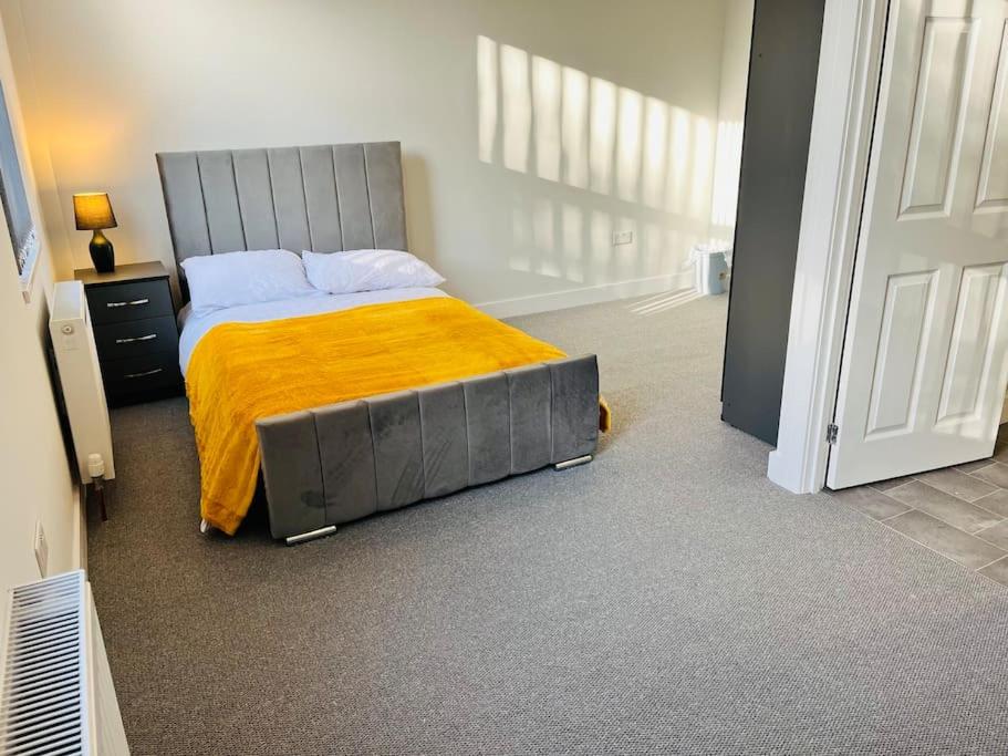 - une chambre avec un lit et une couverture jaune dans l'établissement Cheerful newly refurbed 5 bed!, à Derby