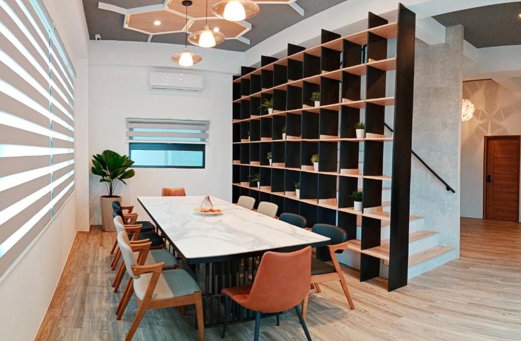 - une salle à manger avec une table, des chaises et une étagère dans l'établissement Ocean Guest House, à Magong