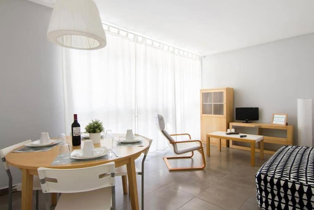 ein Wohnzimmer mit einem Tisch, Stühlen und einem Sofa in der Unterkunft Cute tiny flat near the beach and city center in Tossa de Mar