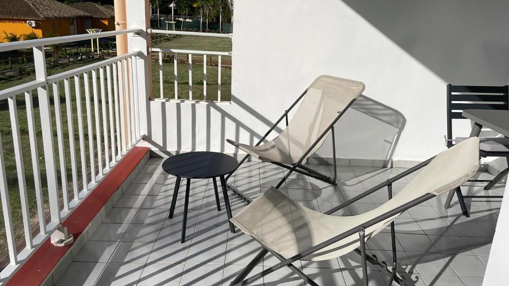 two chairs and a table on a balcony at Village Kawann - Toumalacai 246 in Grand-Bourg